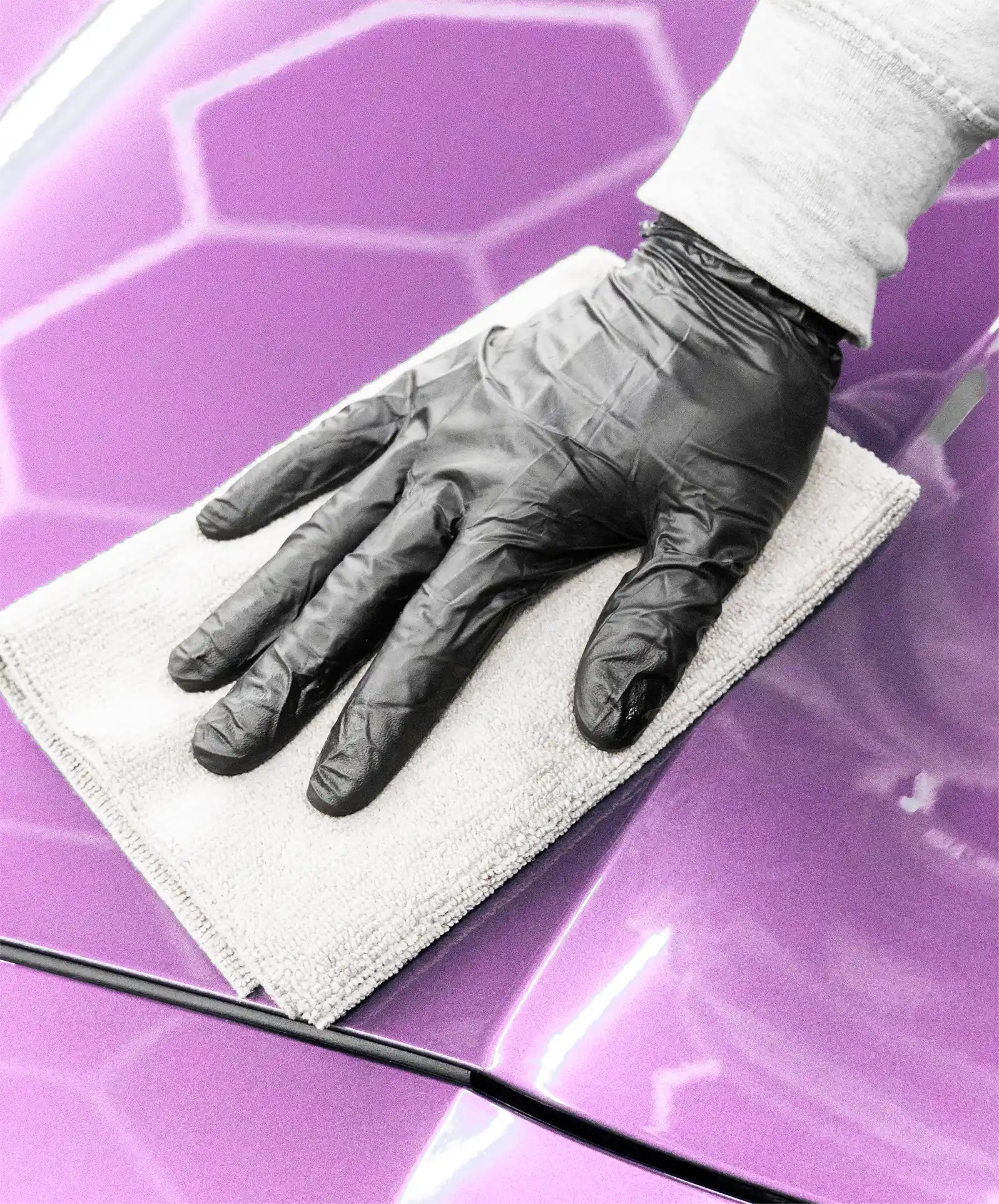 Ruka zaměstnance Miracle garage tábor otírající utěrkou zářivě fialovou kapotu super sportovního auta.