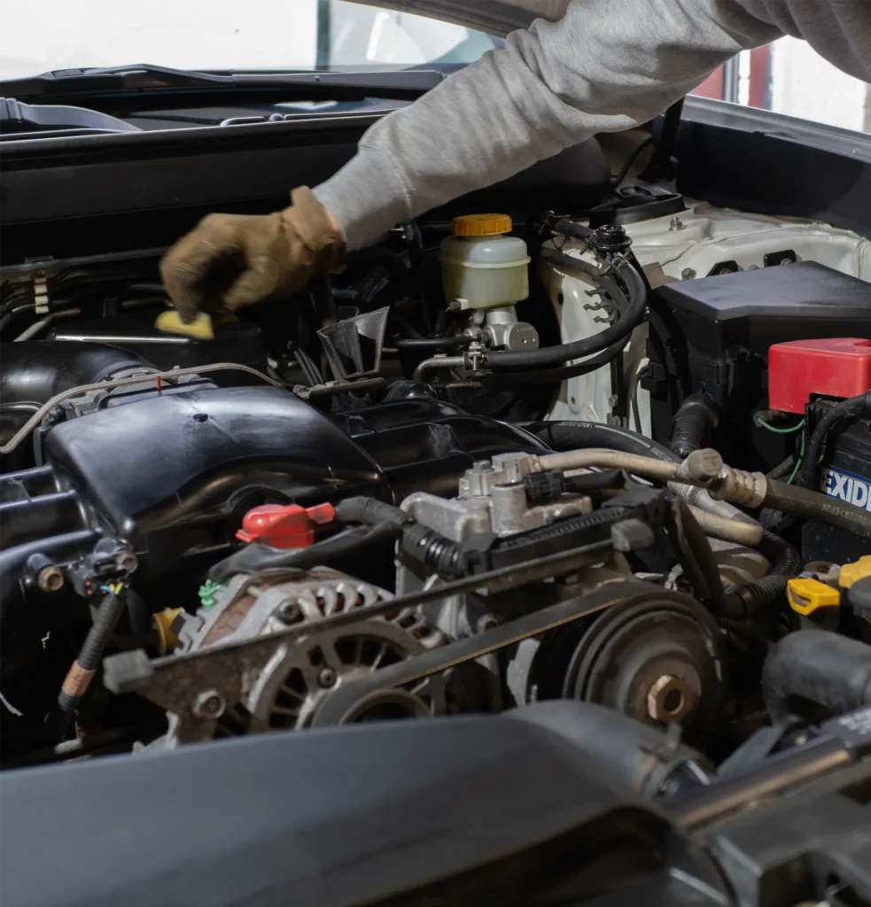 Ruka zaměstnance Miracle garage Tábor čistící motorový prostor auta po dokončení základního servisu.